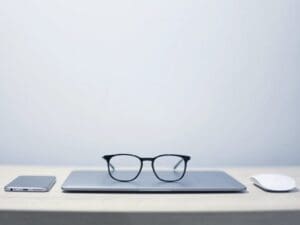 óculos de grau em cima de um notebook simbolizando tipos de escalas de trabalho