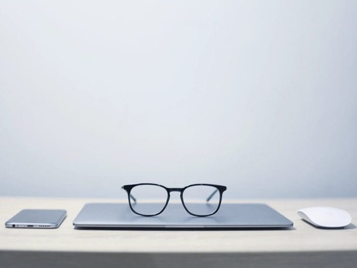 óculos de grau em cima de um notebook simbolizando tipos de escalas de trabalho