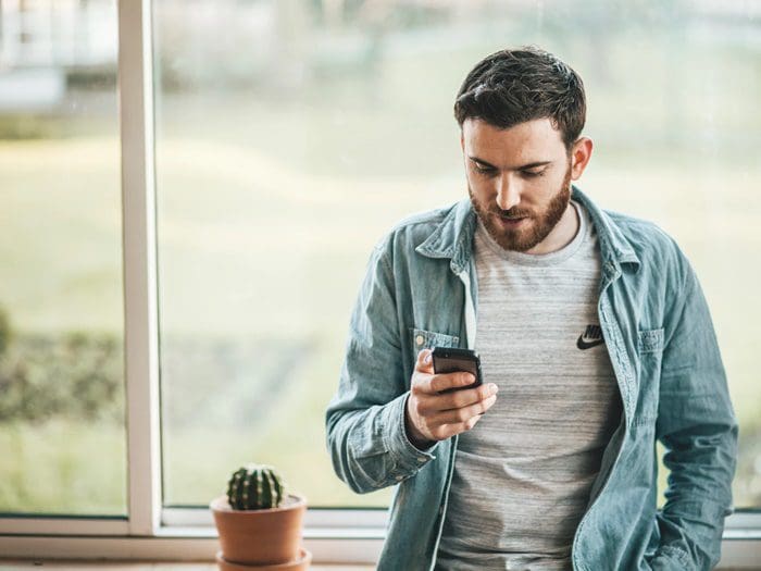 homem segurando um celular simbolizando ponto eletrônico