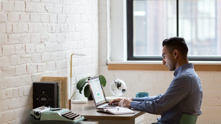 Imagem de um homem trabalhando em uma mesa ao usar o seu notebook, para representar o conteúdo sobre as portarias 1510 e 373