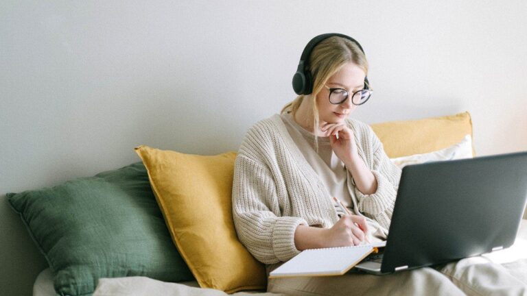 Imagem de uma mulher fazendo seu home office no quarto