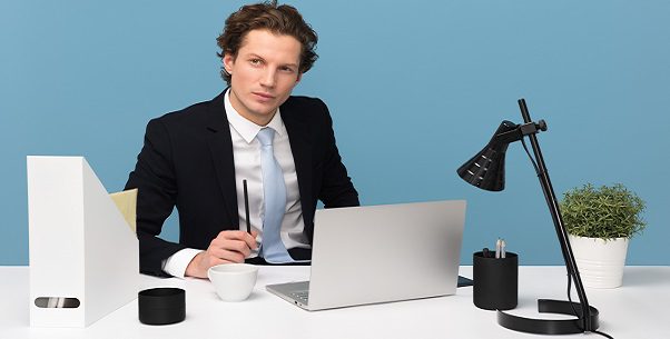 Imagem de um homem branco em uma mesa, segurando um lápis na frente de um notebook. Imagem usada para simbolizar o artigo sobre PJ pode bater ponto