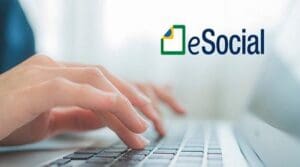 Imagem de uma mão digitando em um teclado, com o escrito eSocial no canto superior direito