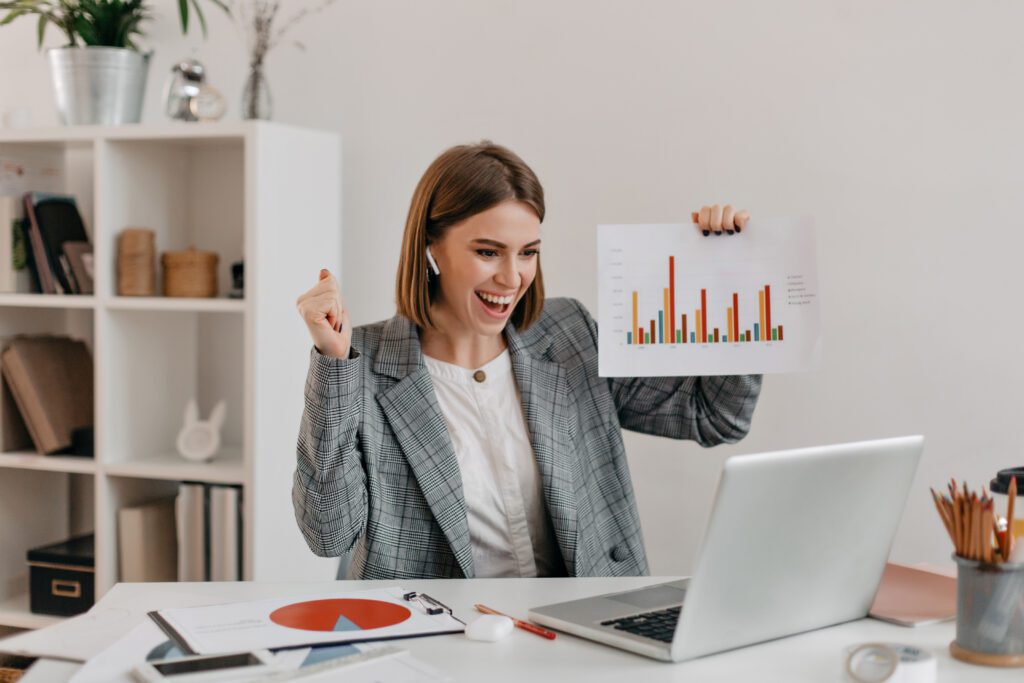 Mulher em reunião no notebook apresentando gráficos