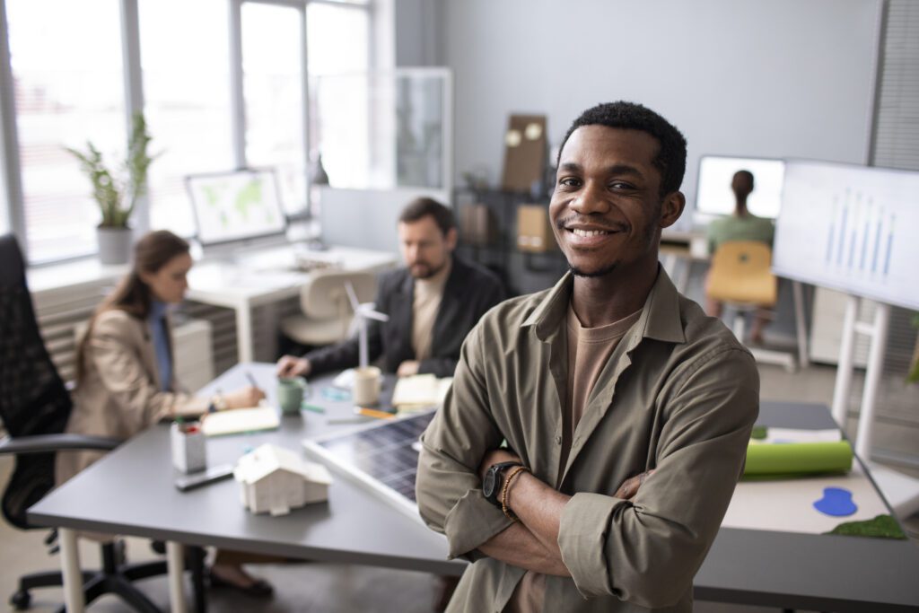 Homem negro sorrindo e com os braços cruzados