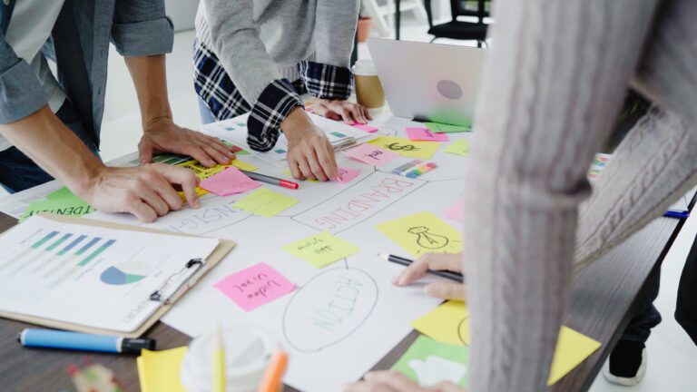 Grupo de pessoas de negócios vestidas casualmente discutindo ideias no escritório. Profissionais criativos reunidos na mesa de reunião para discutir as questões importantes do novo projeto de startup bem-sucedido.