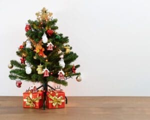 Uma foto de uma árvore de Natal decorativa com presentes embaixo dela