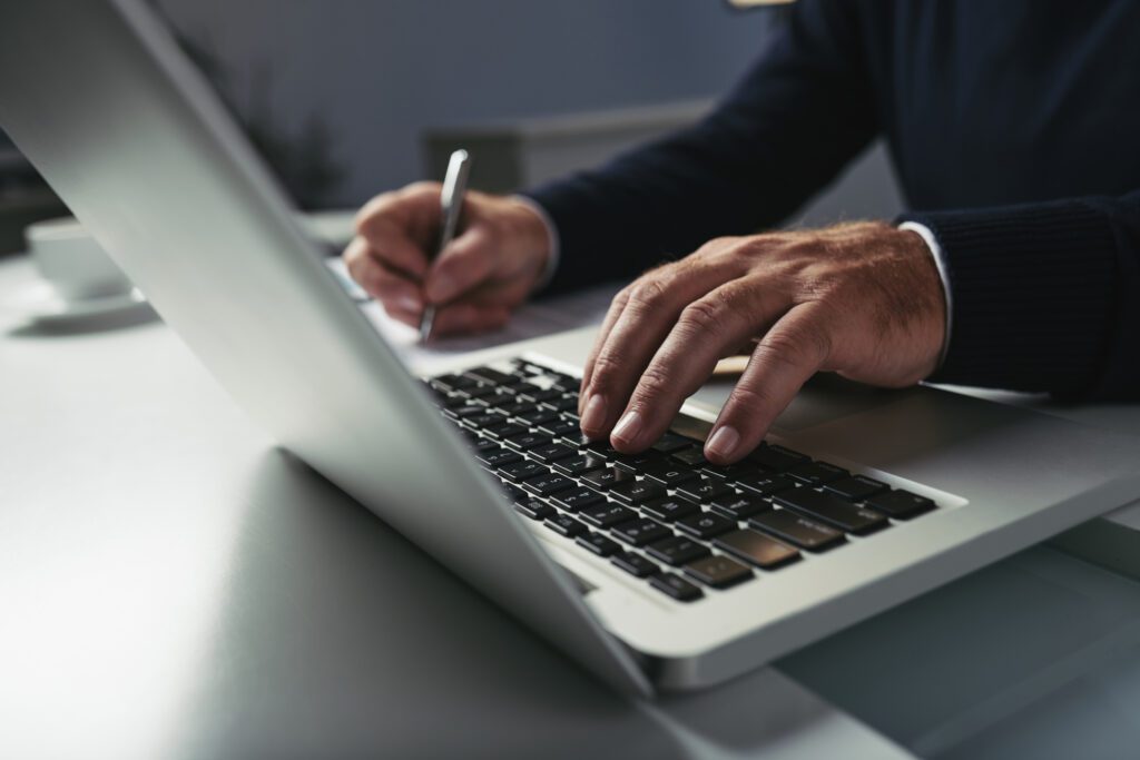 Imagem em close-up de um empresário trabalhando em um laptop em sua mesa