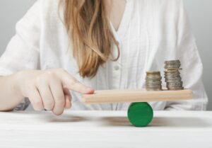 Mulher segurando balança equilibrando moedas