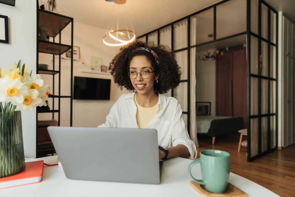 Mulher negra trabalhando de casa usando um computador