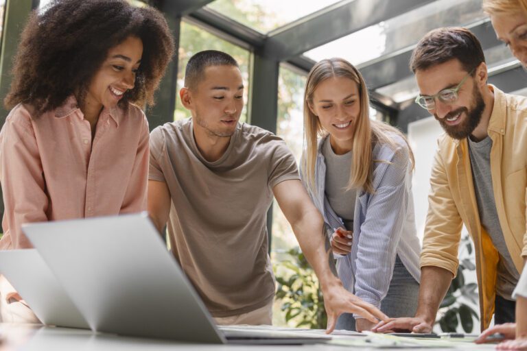 Grupo de pessoas reunidas em volta de um notebook